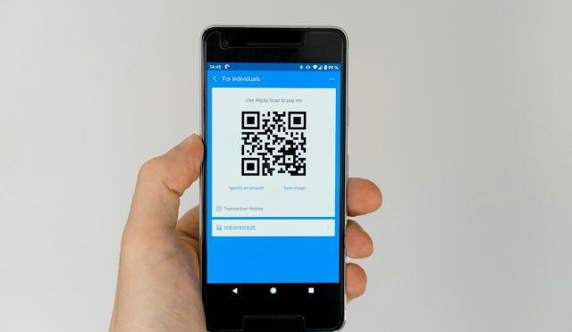 Akıllı telefonla QR kod tarayan kişi ve QR kod güvenliği
